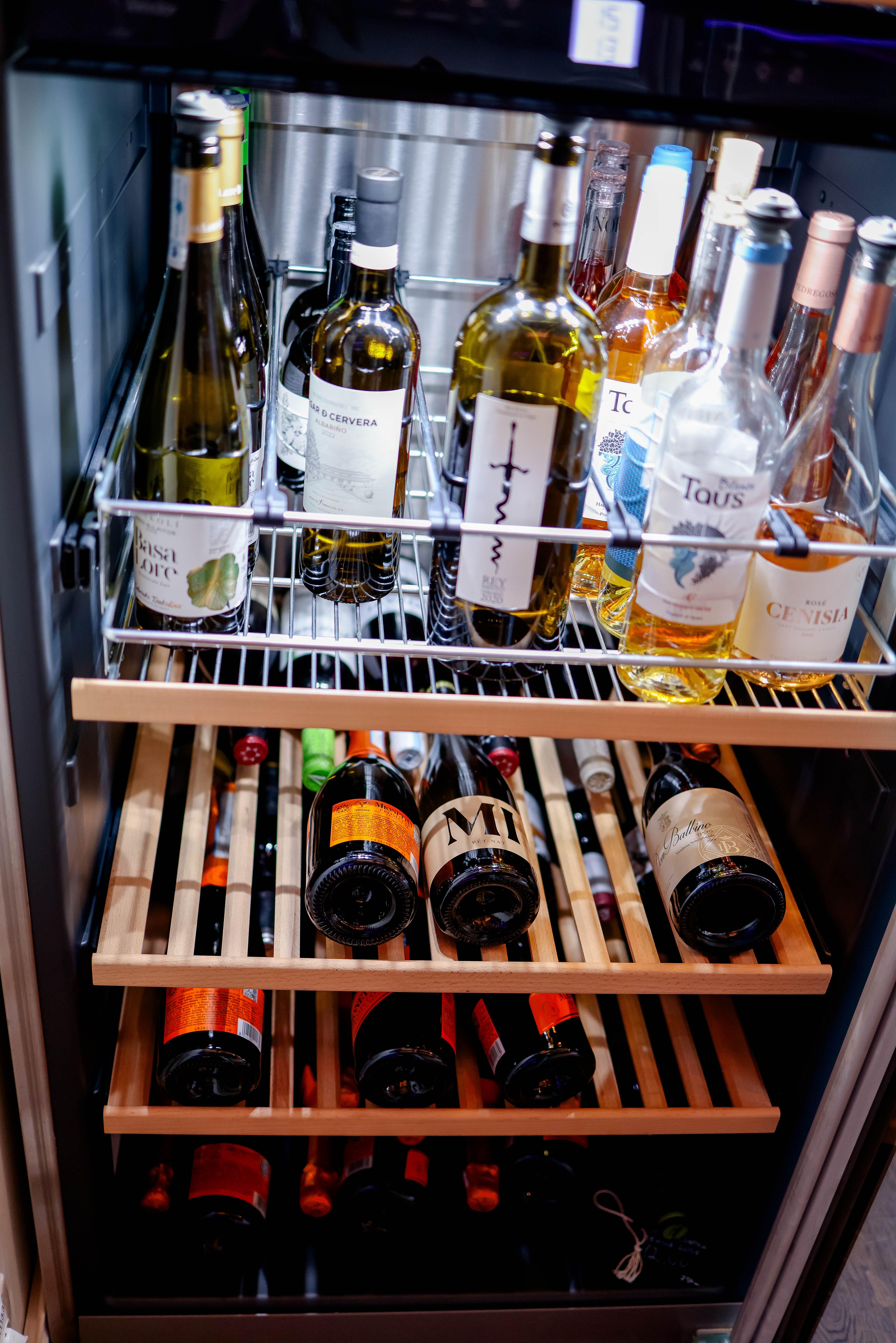 Bottles arranged on wooden racks inside a wine cooler