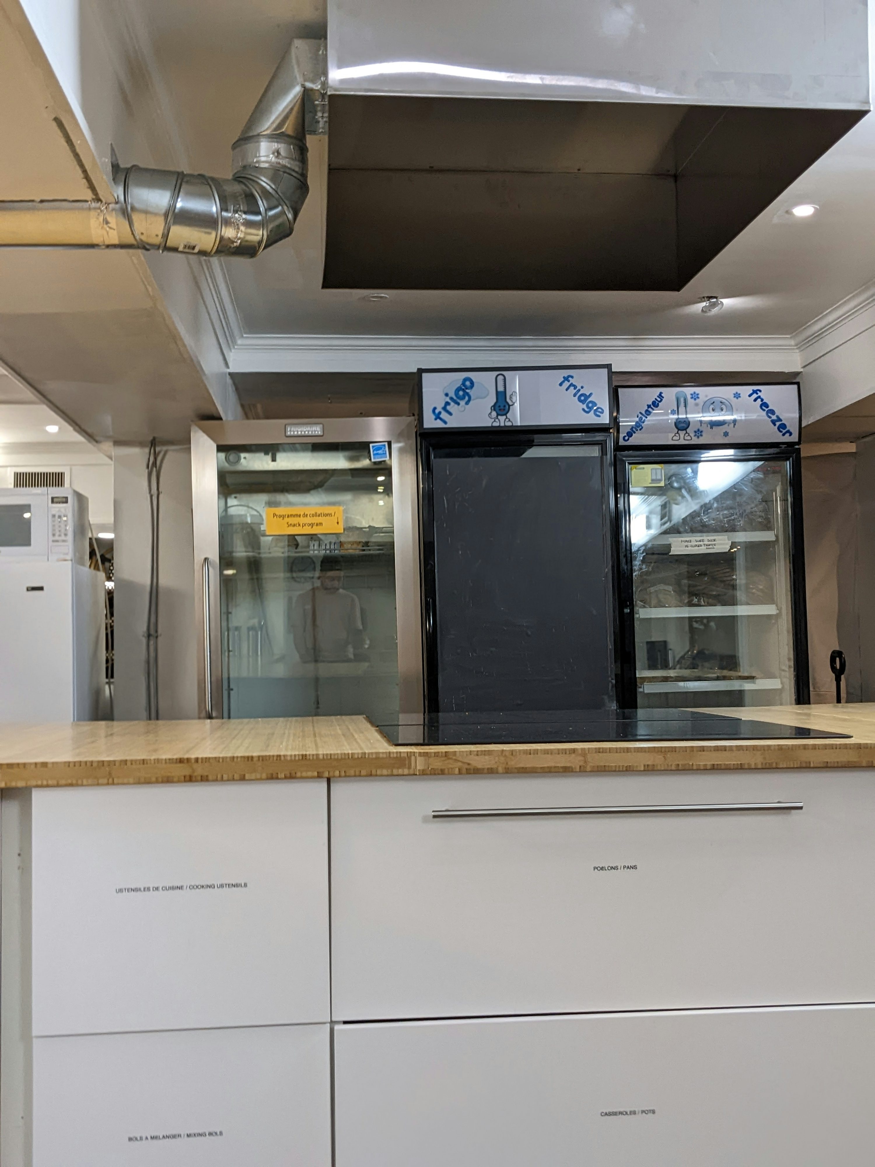Restaurant kitchen with commercial refrigerators and ventilation hood