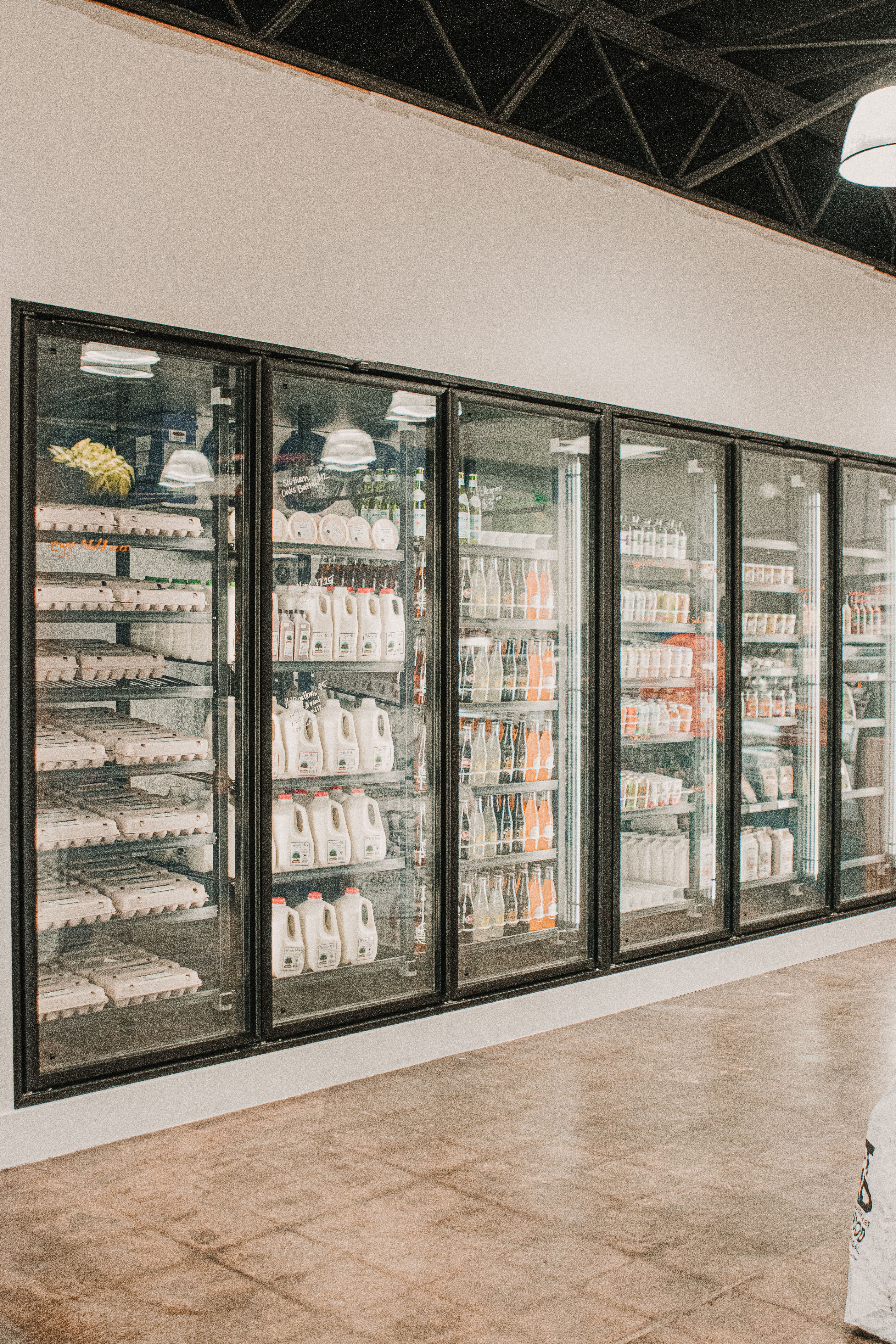 Refrigerated dairy cases with glass doors in a grocery aisle