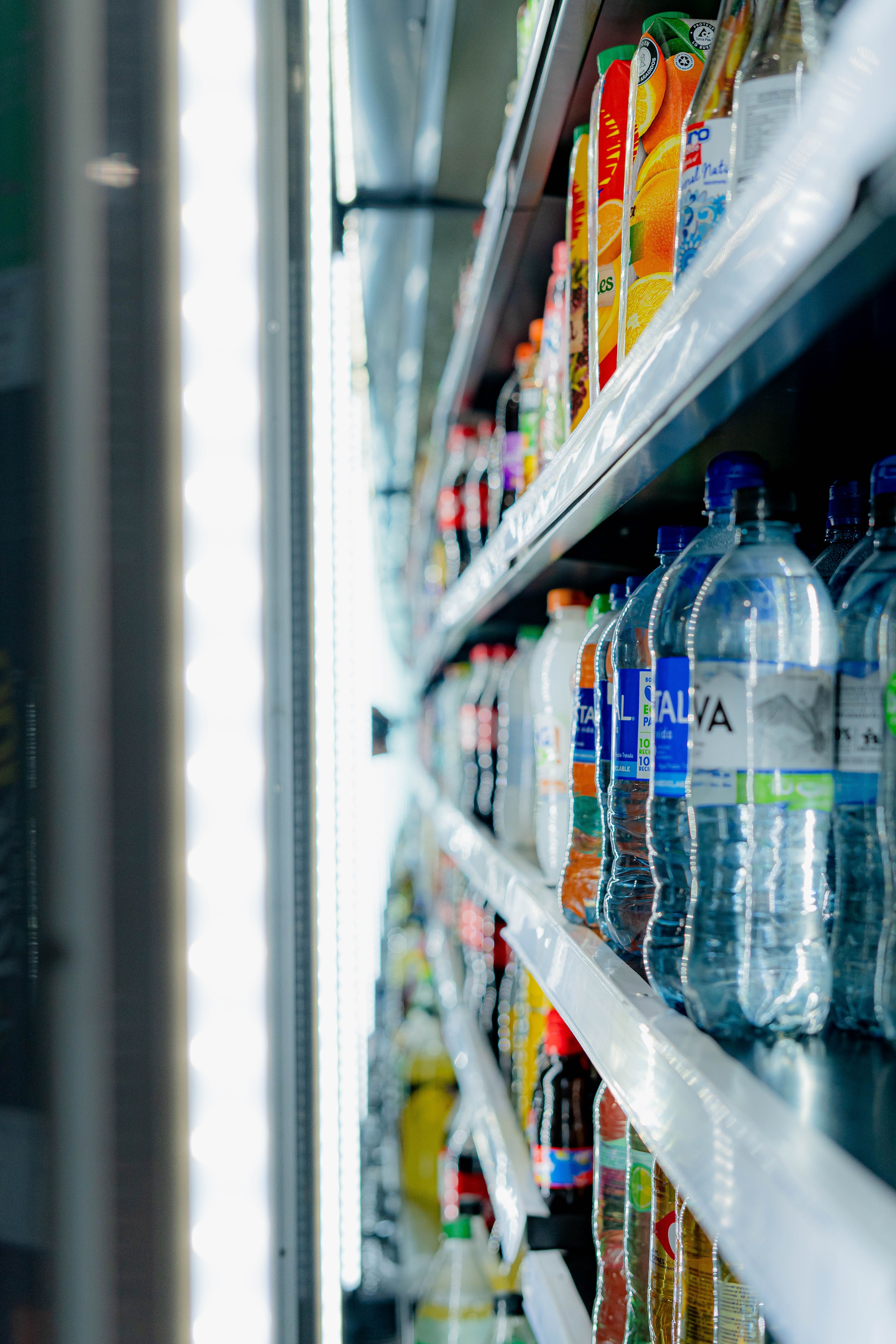 Chilled bottled drinks arranged on commercial refrigerator shelves