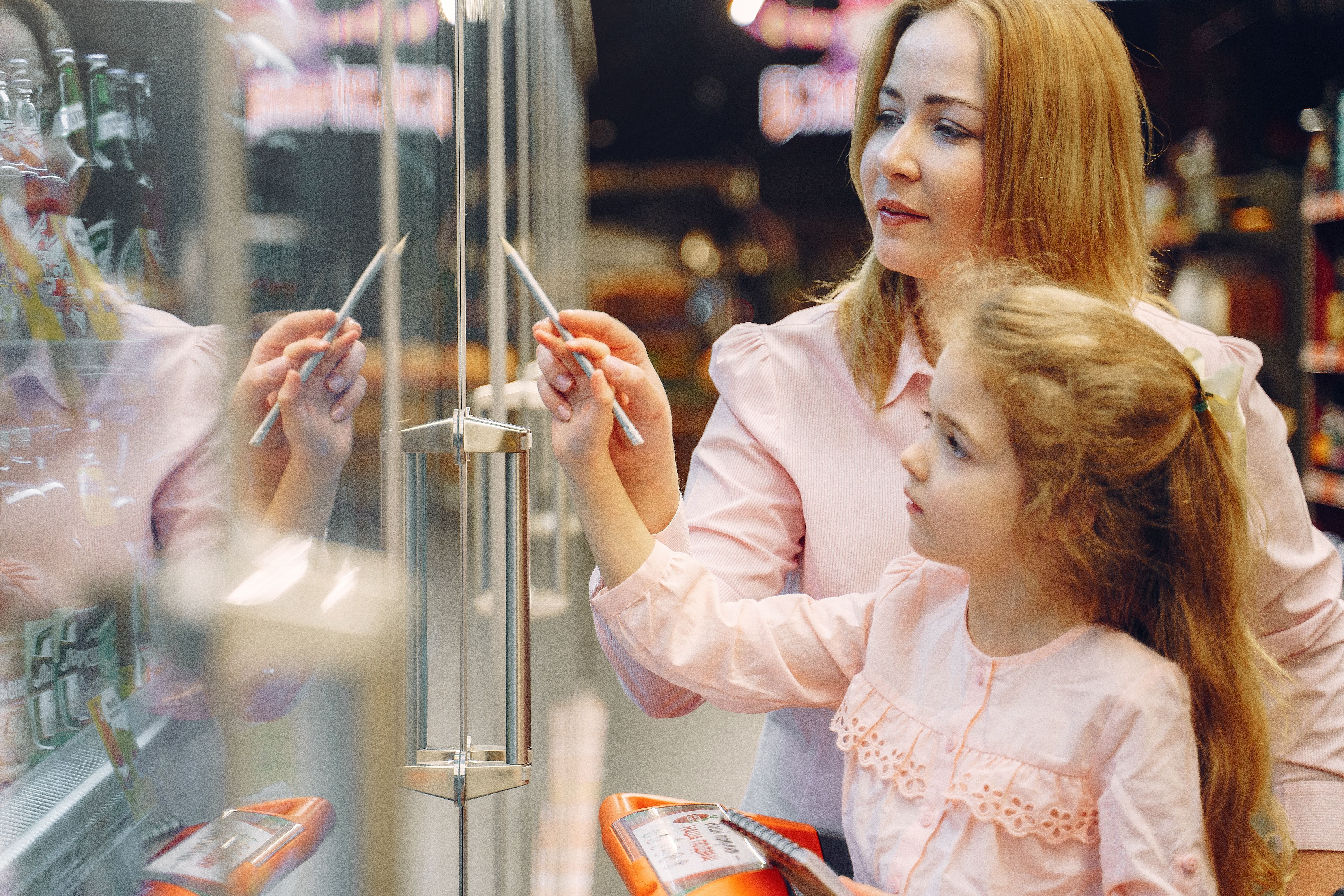 Customers beside a glass-door commercial refrigeration case