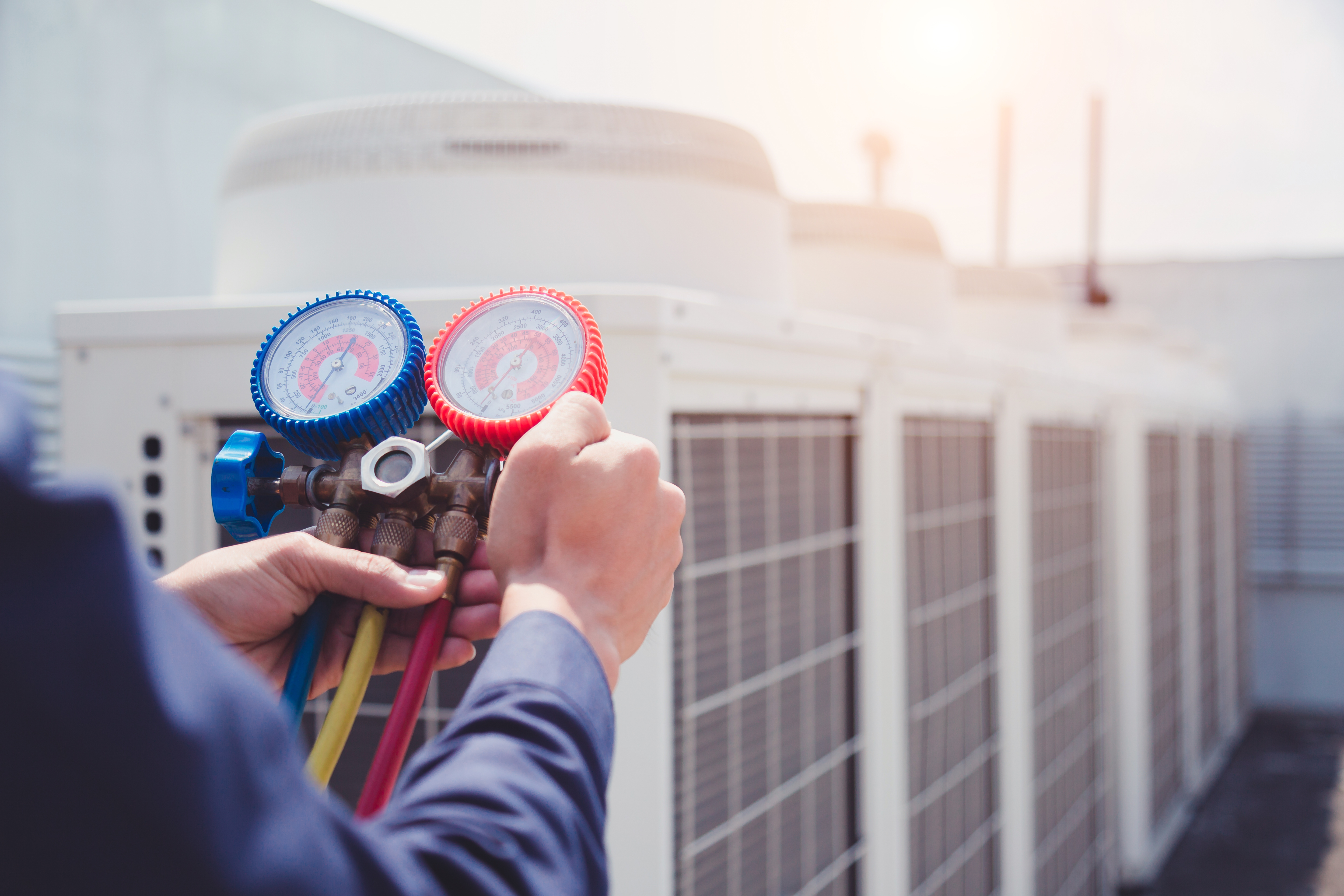 Service technician checking refrigeration pressure gauges