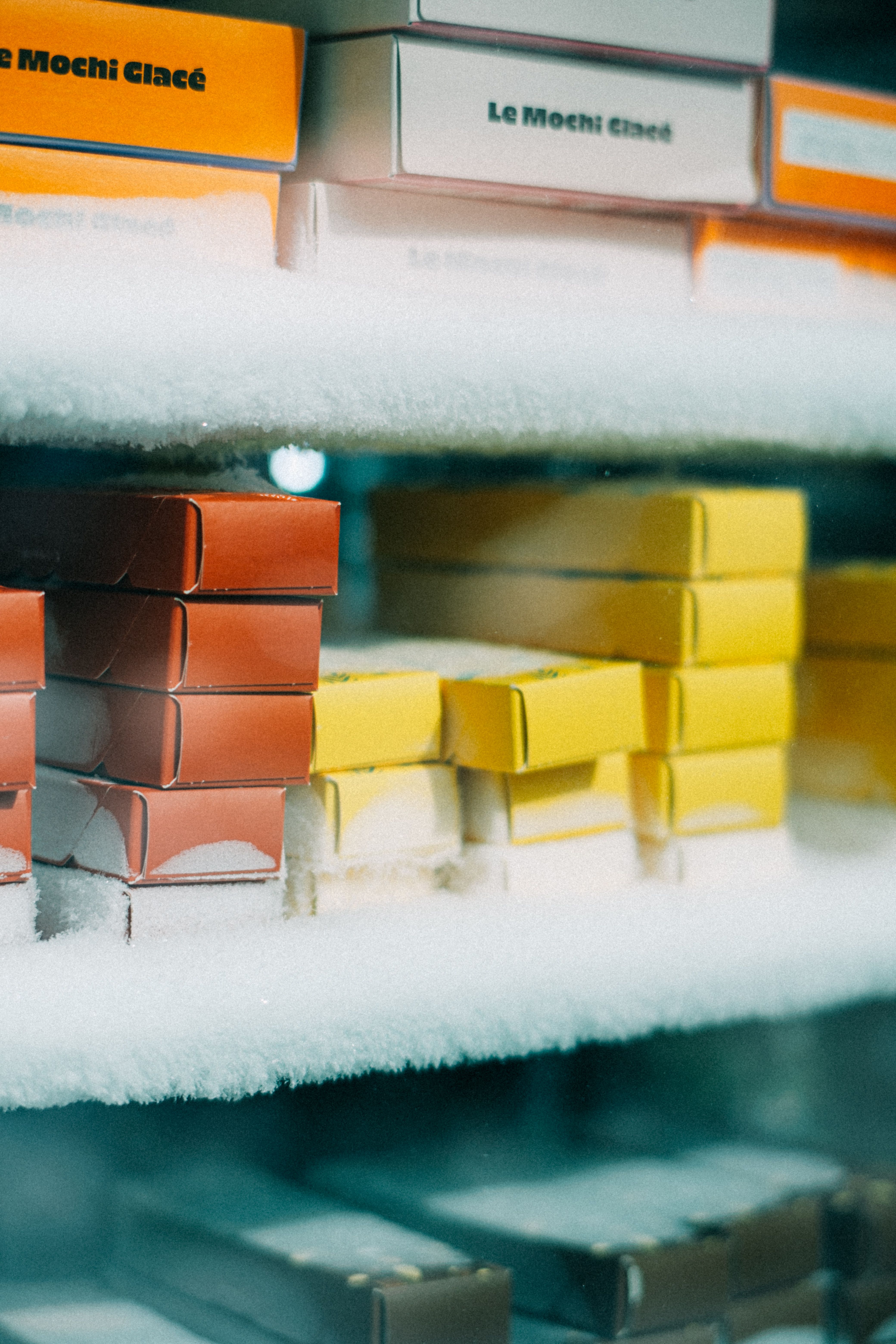Frozen desserts on frost-covered shelves inside a display freezer
