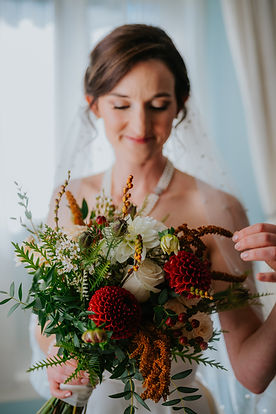 bride admiring her fall bridal bouquet