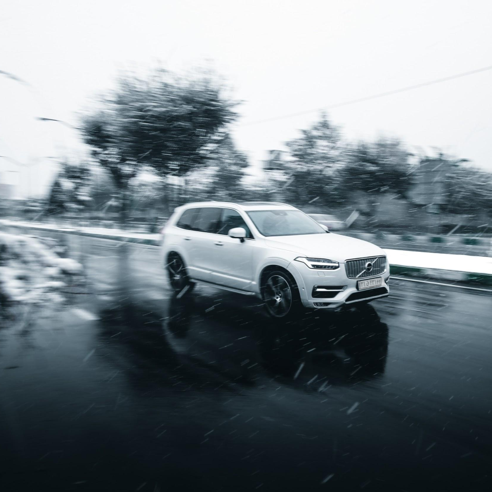 SUV driving on road while snowing