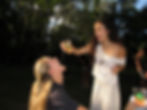 Girl pouring drink into another girl's mouth
