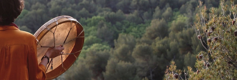 Lucie Richard tenant un tambour face à la forêt – symbolique de la reconnexion au corps et à la nature.