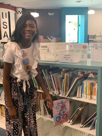 Jasmine Simmons shows her book on the library shelf at the Lancaster County Library. 