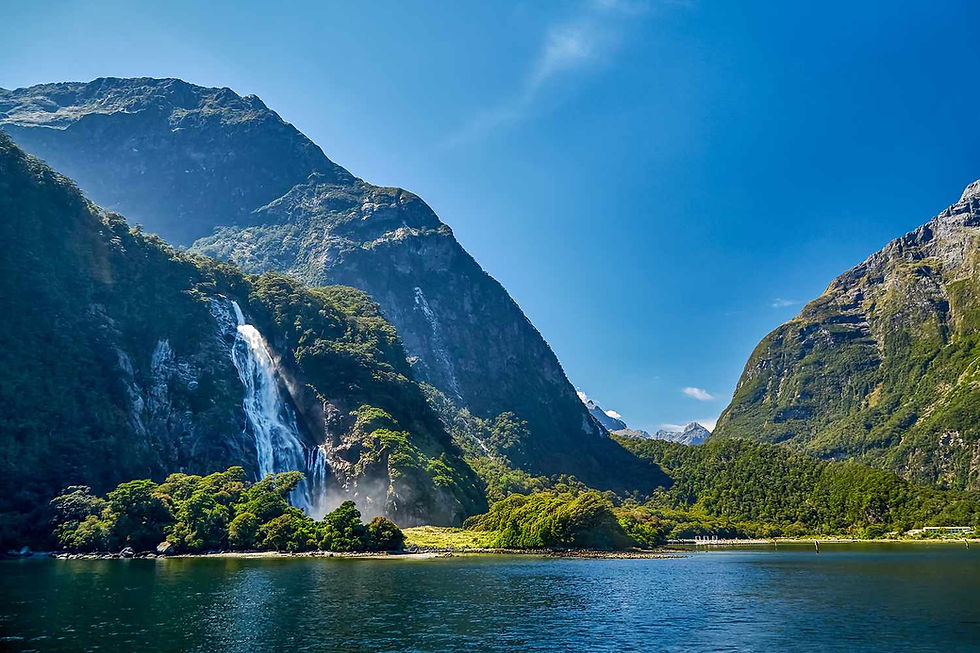 gorgeous lake in front of mountain with large cascading waterfall. Scene from New Zealand.