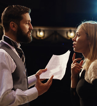 Medium shot of actors rehearsing in a th