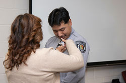 mother pins badge on son