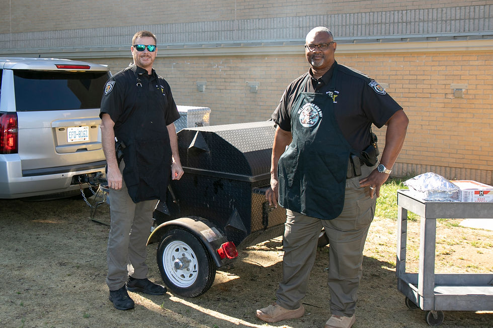 Two deputies cook on gas grill for senior picnic
