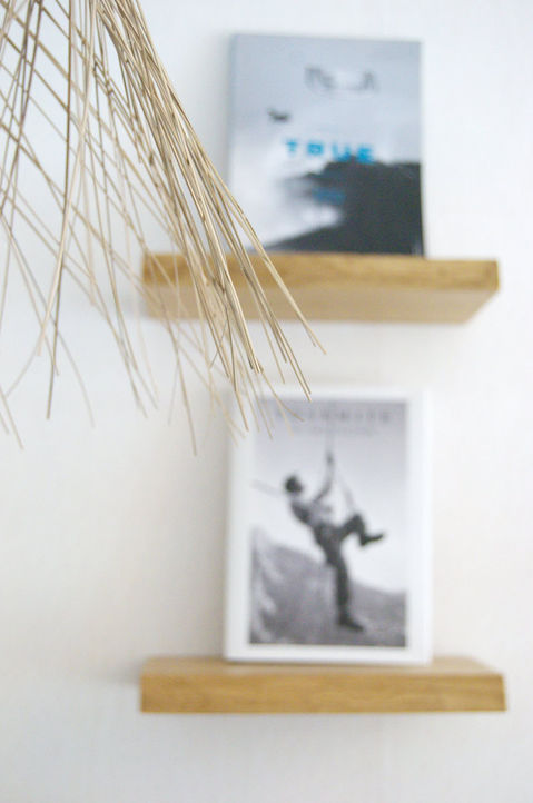 Holzregale mit Büchern und Pampasgras