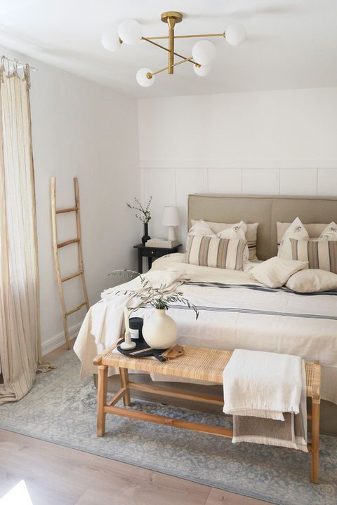 Helles Schlafzimmer mit großem Bett und goldener Deckenleuchte