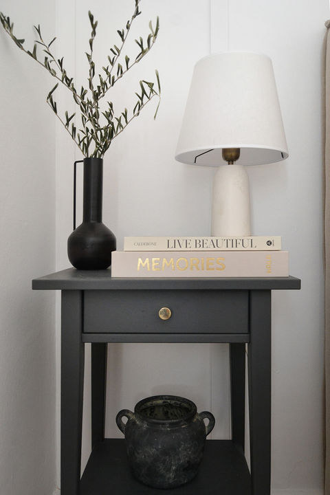 Dunkelgrauer Nachttisch mit Lampe, Vase und Büchern