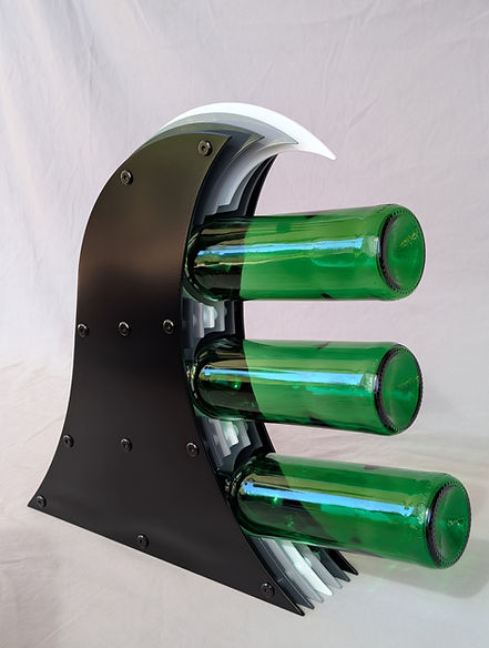 Crashing wave wine rack built from layered aluminum sheets with gradual colour change.