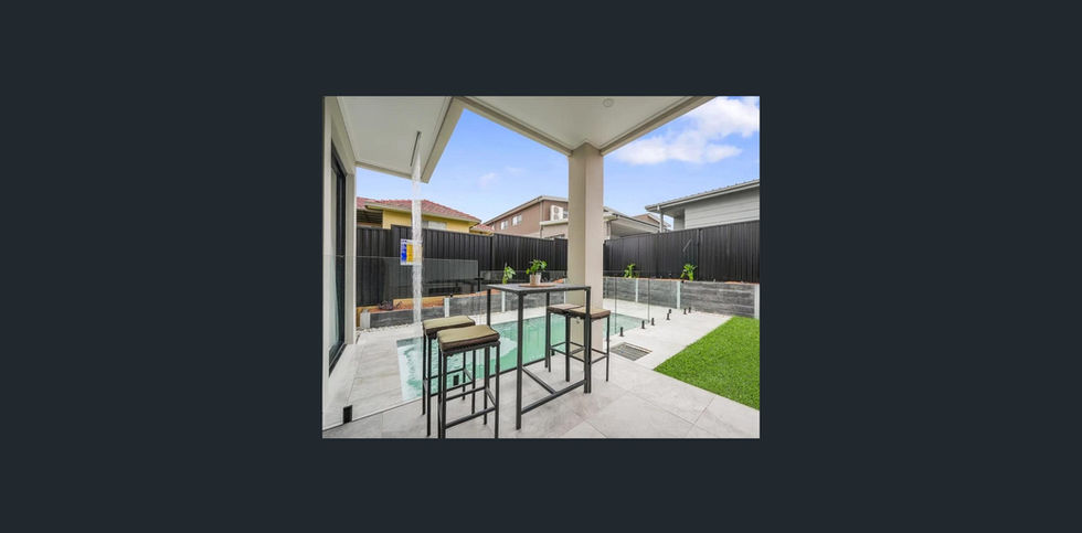 a patio with a table and stools next to a pool