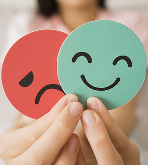 Preteen hands holding sad face hiding behind happy face, bipolar and depression, mental he