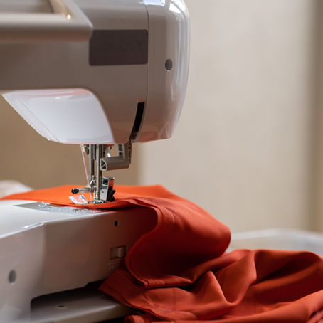 Close up of orage fabric in a sewing machine