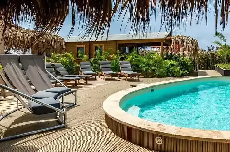 Kleinschalig resort op Bonaire met houten cabana’s, tropische beplanting en een rustig privézwembad
