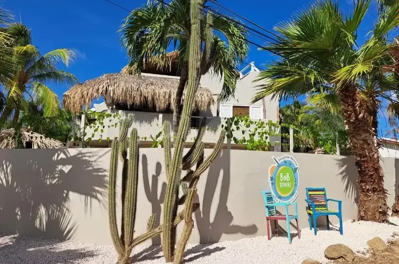 Buitenzijde van BnBBonaire met tropische cactussen en palmbomen