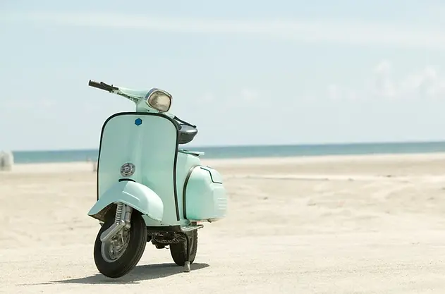 Een klassieke scooter geparkeerd op het strand van Bonaire, klaar voor een dag vol avontuur.