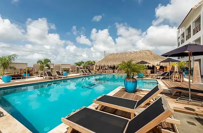 Comfortabel resort op Bonaire met zwembad, ligbedden en een gezellige palapa bar onder een rieten dak