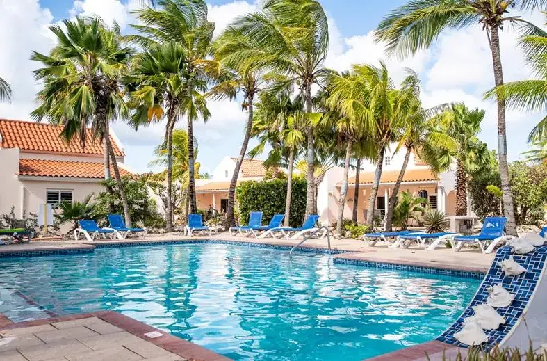 Zwembad Hamlet Oasis Bonaire met blauwe ligstoelen
