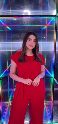 Mulher de vermelho em túnel de Led colorido espelhado.