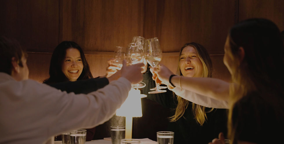 a group of four people clinking their glasses celebrating
