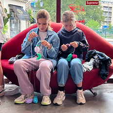 Two kids relax on a red couch during an after school workshop at The Chillie Kids Club.