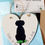 Thumbnail: A white hand painted heart decoration showing a silhouette of a dog with green sea glass embellishments.