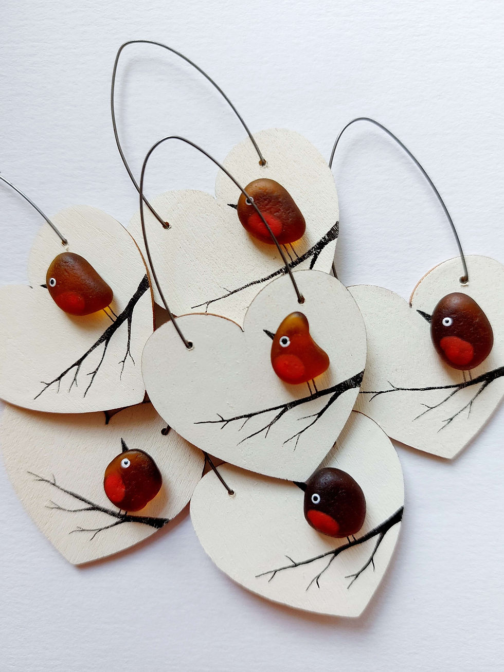 Thumbnail: White wooden heart decorations embellished with a brown sea glass robin perched on a branch, shown on a white background.
