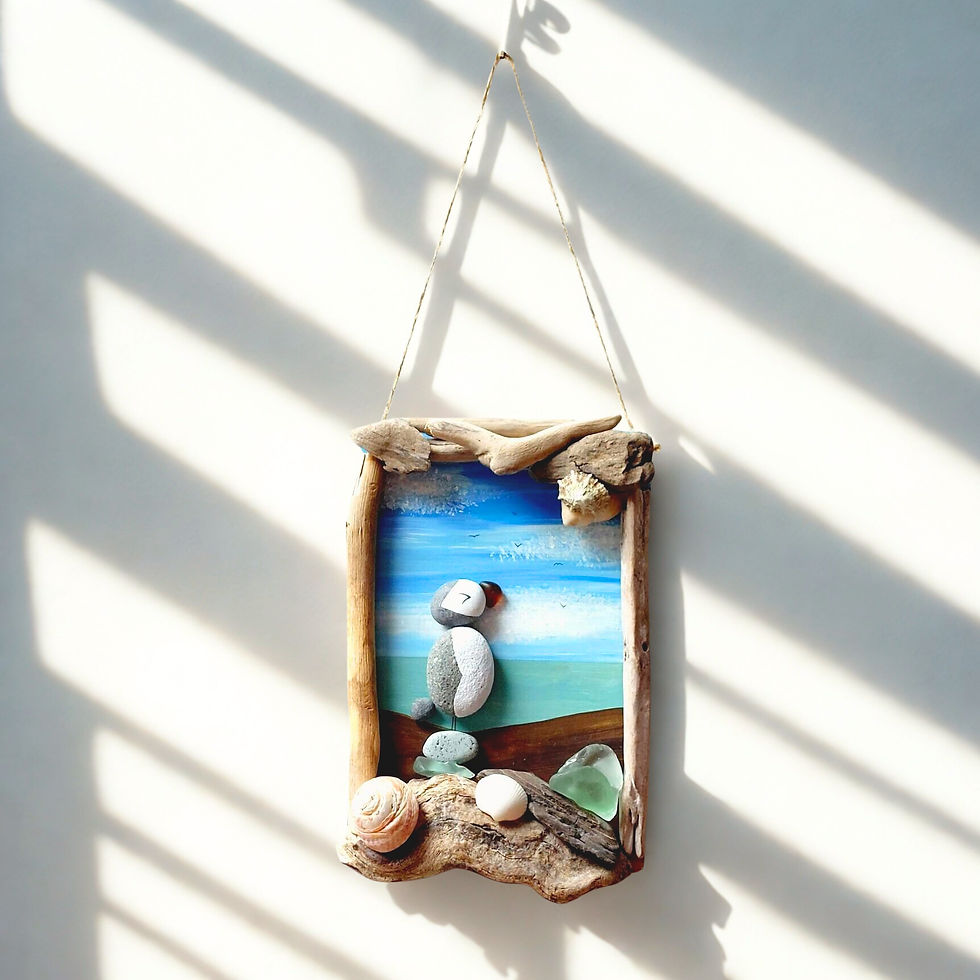 A puffin wall art made from driftwood, shells, sea glass and showing a puffin made from painted pebbles