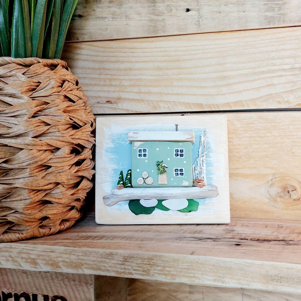 Thumbnail: Rustic wooden wall art, showing a wooden backboard, decorated with a green Christmassy cottage, with driftwood and sea glass