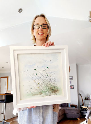 Craft Happy owner, Helen, holding a piece of sea glass artwork