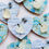 Thumbnail: Heart shaped magnets with a blue pattern on them and a sea glass bird holding dandelions in its beak.