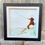 Thumbnail: A black framed 3D watercolour picture of a sea glass angler on a hand painted riverbank.
