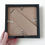 Thumbnail: A hand holding a black frame, the reverse of which is shown, to demonstrate display stand.