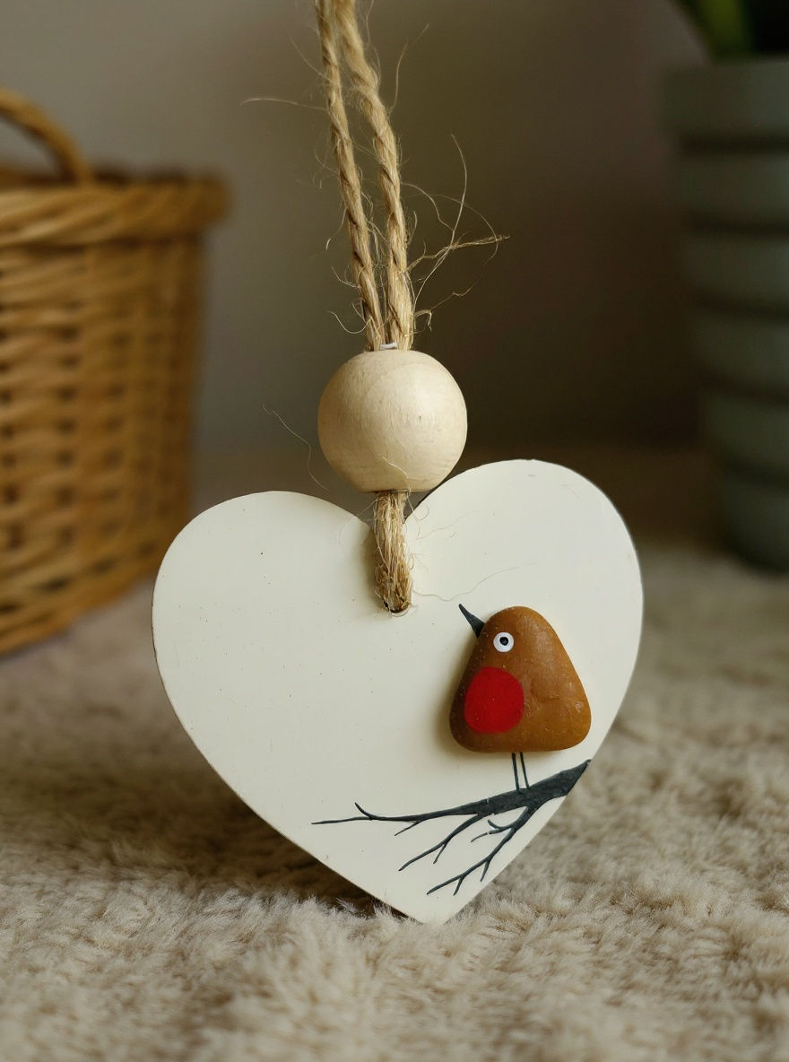 White wooden heart decorations embellished with a brown sea glass robin perched on a branch, shown on a white background.