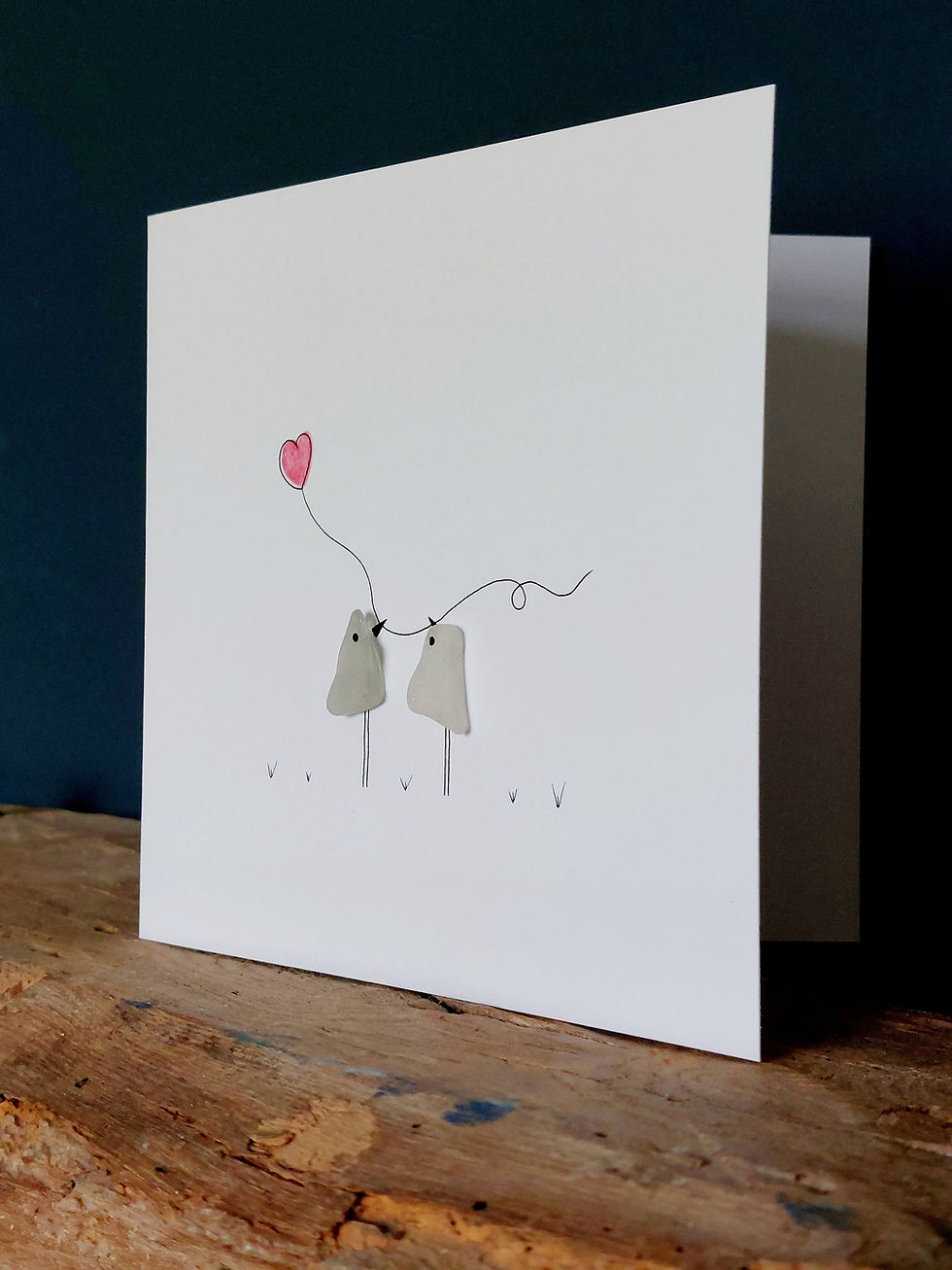 Thumbnail: A greetings card decorated with sea glass showing 2 birds with a heart balloons in their beaks.