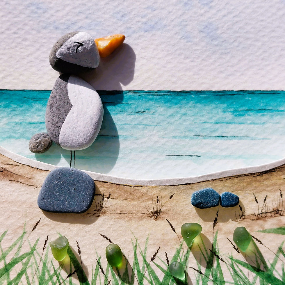 Thumbnail: A black framed 3D watercolour painting of an blue ocean with grasses and sand dunes in the foreground and a pebble puffin.