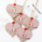 Thumbnail: A wooden heart hanging decoration decorated with a sea glass robin. The heart has been painted pink with hand drawn details.