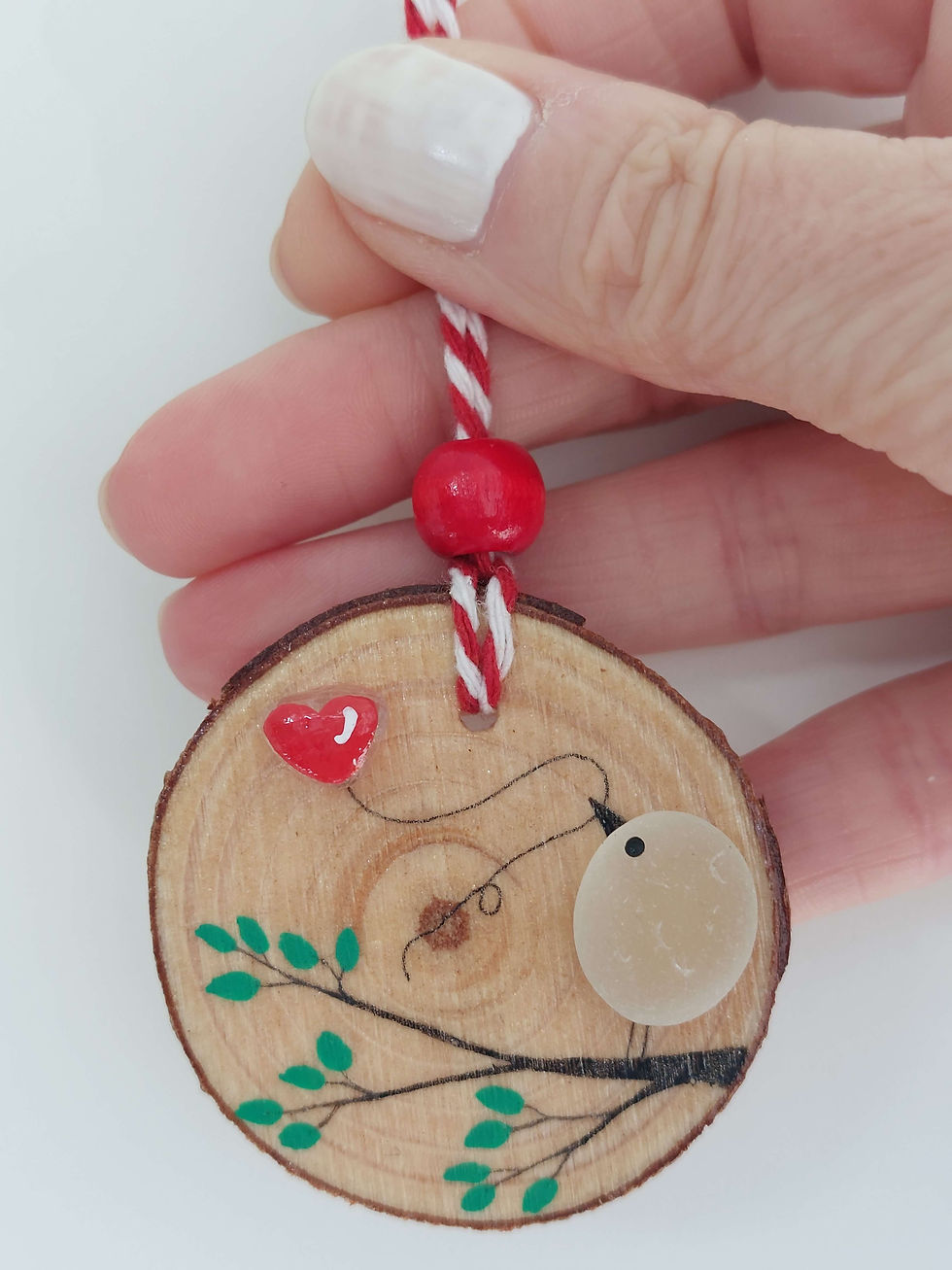 Thumbnail: Wood slice hanging decoration showing a sea glass bird on a branch holding a red heart balloon, close up photo to show detail