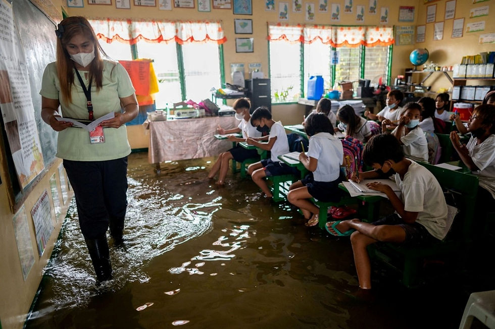 Figure 3: Learning in a partially flooded classroom in the Philippines (Magsambol, 2022)