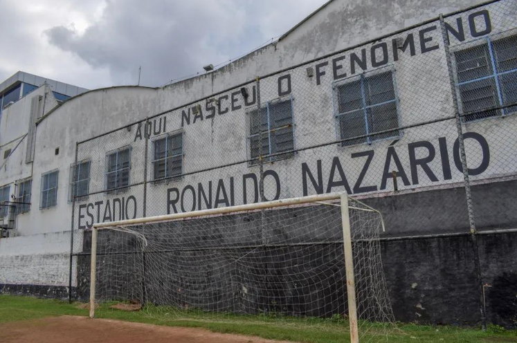 Ídolo eterno e cria da casa: Ronaldo Nazário estampado na entrada do estádio mantém viva a conexão entre o passado glorioso e o presente resistente do São Cristóvão. Foto: Stephano de Souza