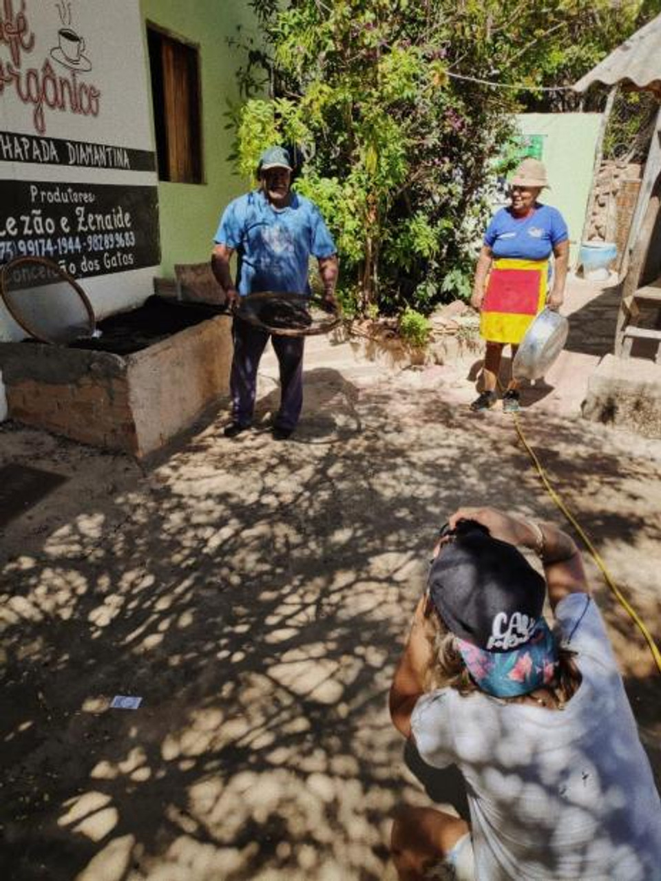 Ensaio fotográfico de casal, produtores de café orgânico no Vale do Capão - Chapada Diamantina (BA), sorrindo a luz do dia em sua loja simples, mas com lições de marketing e experiência de consumo