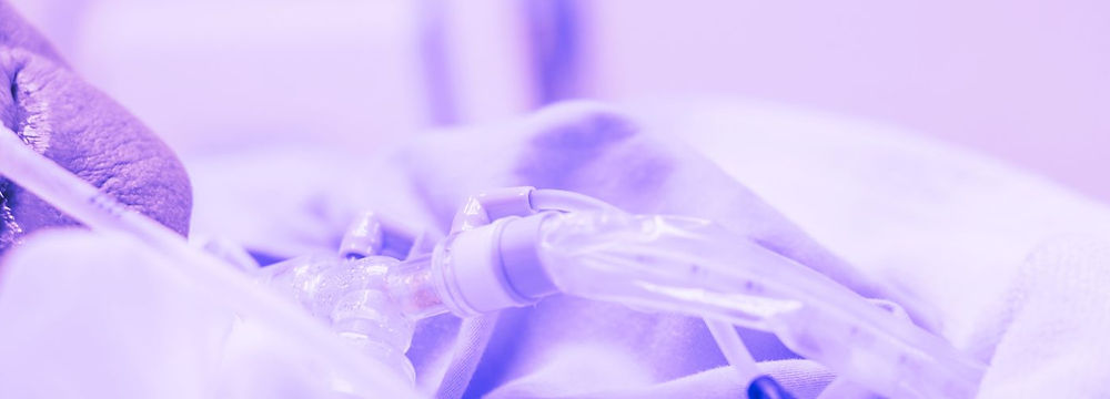 Close-up of tracheostomy tube and securement ties in a clinical care setting during training.