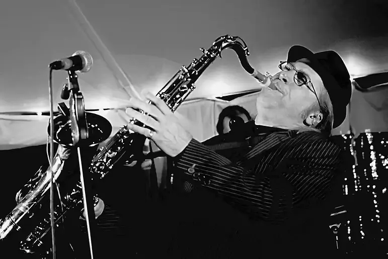 Jazz musician wearing hat performs on saxophone