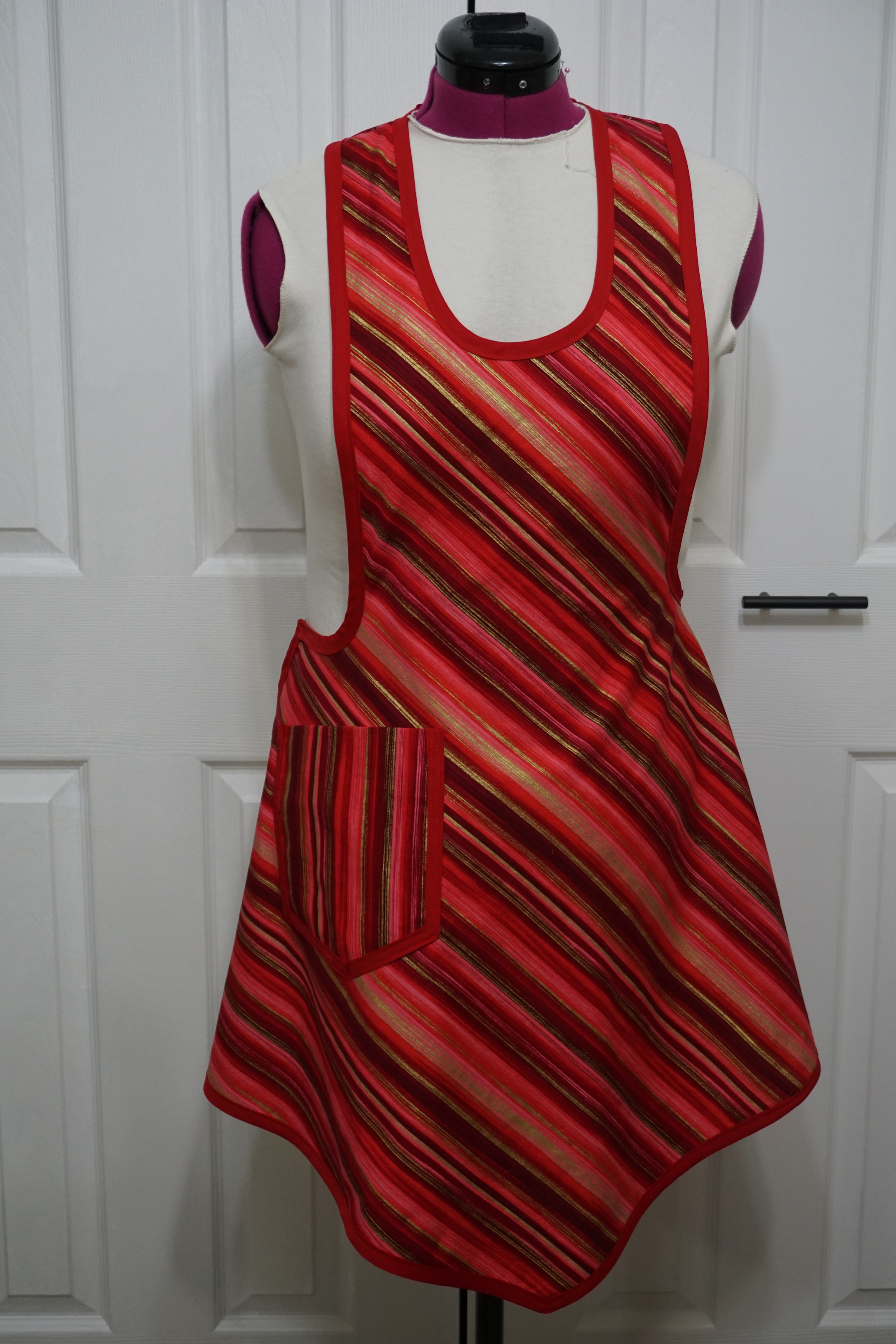 Front view of red and gold striped bib apron